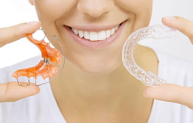 Woman smiling with normal brackets and transparent brackets Retenedor de metal y retenedor Hawley
